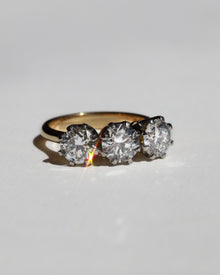 Gold diamond engagement ring with three diamonds on a light gray background. Made in Auckland, New Zealand 