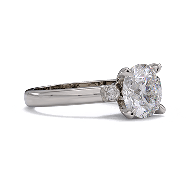 Solitaire diamond ring with round diamond and accent diamonds on the shank.